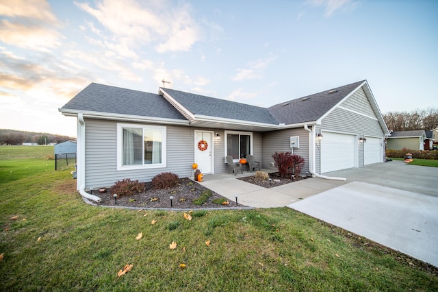 ranch-style house with a garage and a lawn