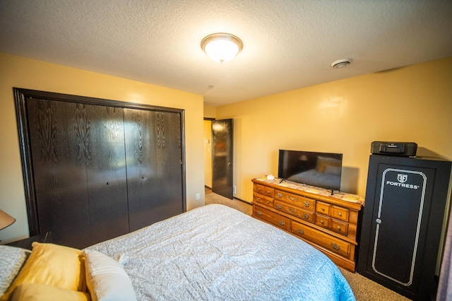 carpeted bedroom with a closet and a textured ceiling