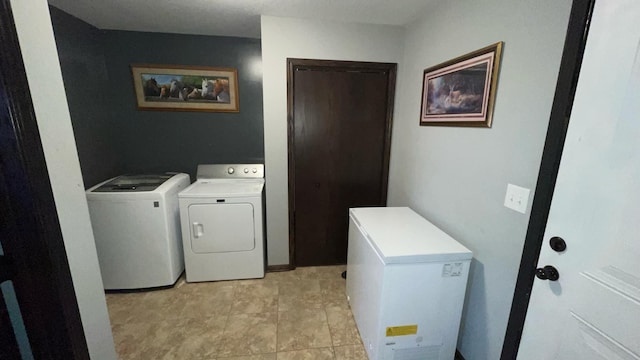 laundry room featuring washing machine and dryer and light tile patterned floors