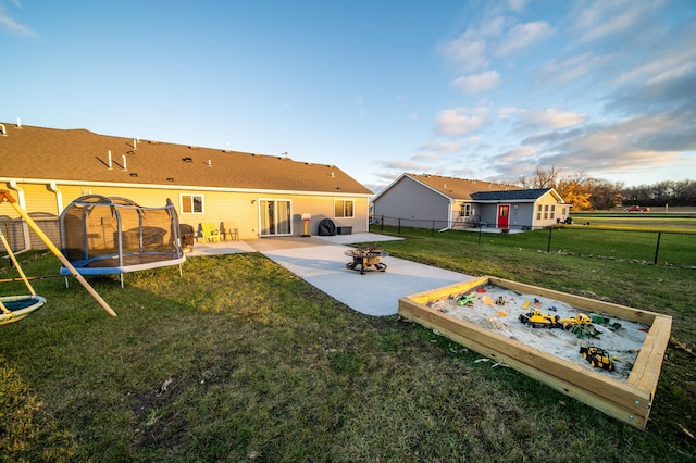 view of yard with a trampoline and a patio