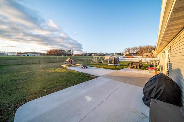 view of patio / terrace with a trampoline, grilling area, and a fire pit