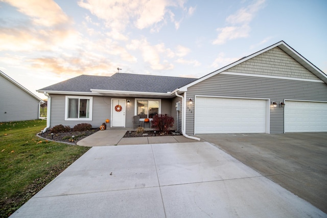 ranch-style house featuring a garage and a lawn