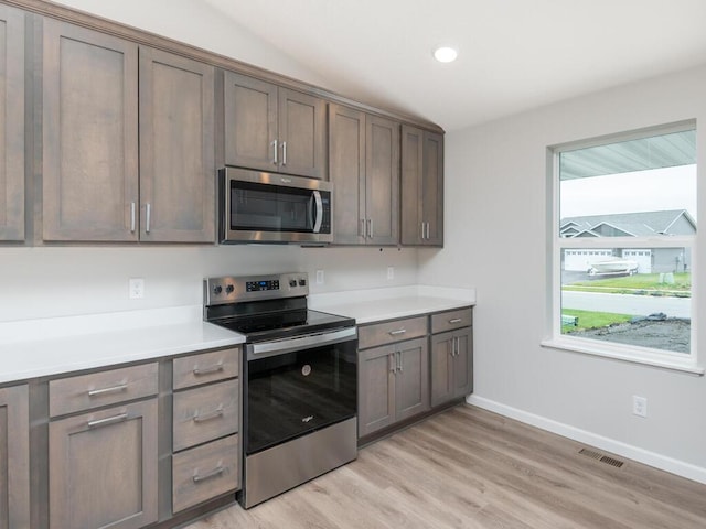 kitchen featuring appliances with stainless steel finishes and light hardwood / wood-style flooring