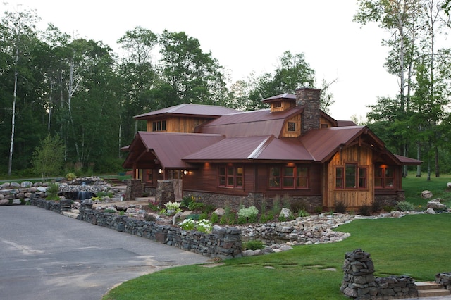 33816 County Road 3, Crosslake, MN 56442 - view of front of house with metal roof, stone siding, a chimney, and a front yard
