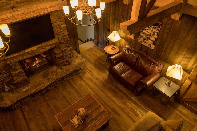 living room with wooden walls, hardwood / wood-style flooring, and beam ceiling