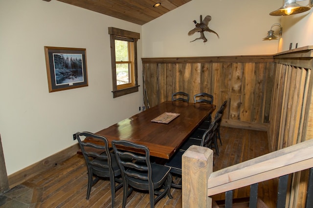 dining space featuring wood ceiling, dark wood-type flooring, wooden walls, and vaulted ceiling