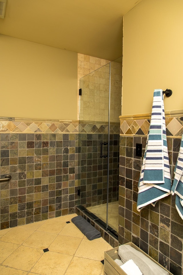 bathroom with an enclosed shower and tile walls