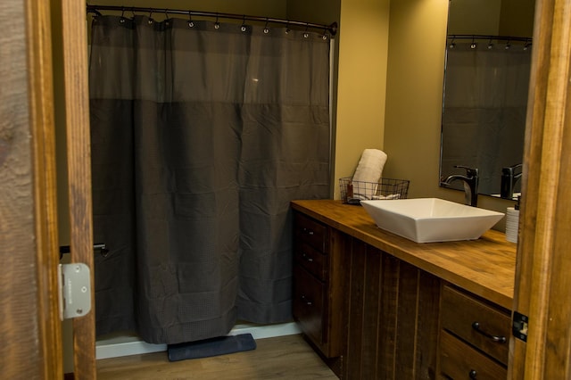 bathroom featuring walk in shower, wood-type flooring, and vanity