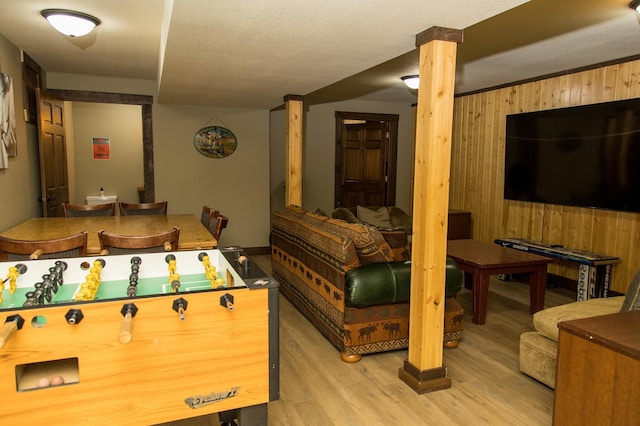 recreation room with wood walls and light hardwood / wood-style floors