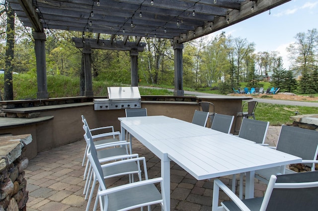 view of patio featuring an outdoor bar, grilling area, and a pergola