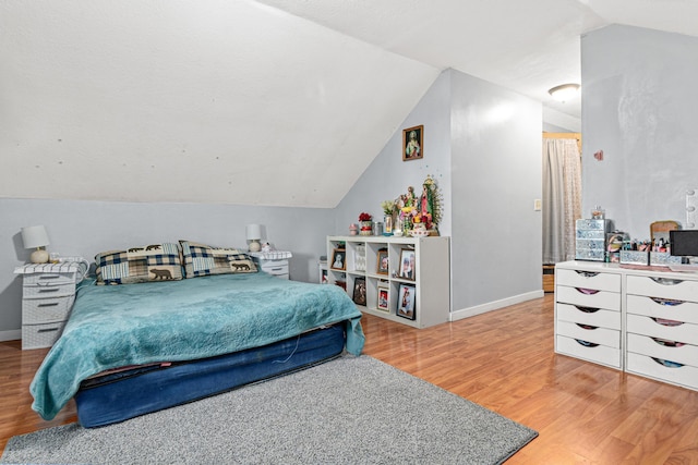 bedroom with wood-type flooring and lofted ceiling