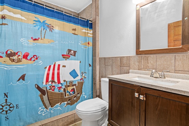 bathroom featuring tile walls, vanity, toilet, and a shower with curtain