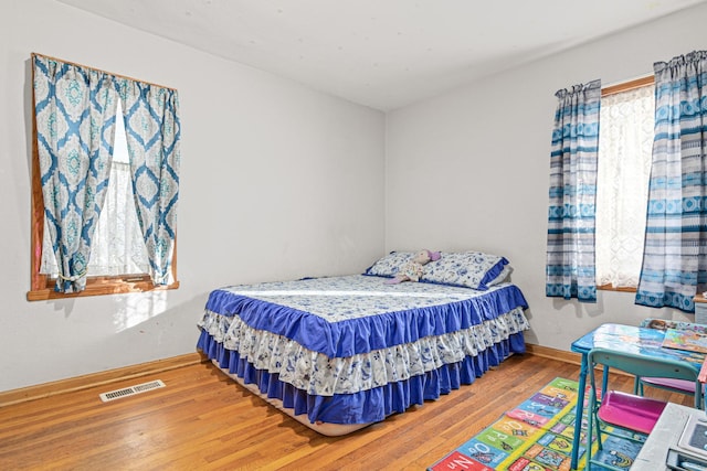 bedroom featuring hardwood / wood-style floors and multiple windows