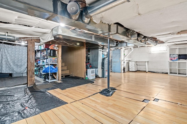 basement featuring hardwood / wood-style flooring and heating unit