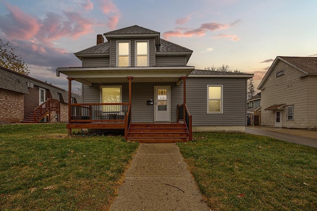 bungalow-style home with covered porch and a yard