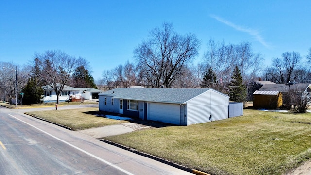 ranch-style house featuring a garage and a front lawn