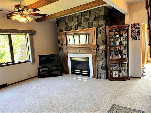 living room with beamed ceiling, carpet, a fireplace, and ceiling fan