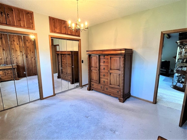 carpeted bedroom featuring multiple closets, wooden walls, and a chandelier