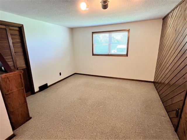 carpeted spare room featuring a textured ceiling