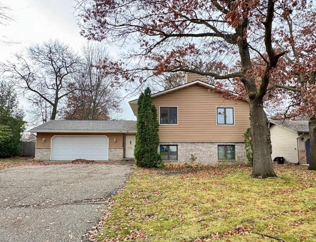 tri-level home with a garage and a front yard