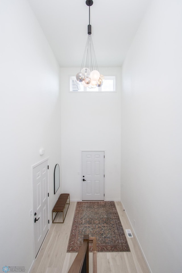 6652 32nd St S, Fargo, ND 58104 - entryway with a chandelier, light wood-style flooring, a high ceiling, and baseboards