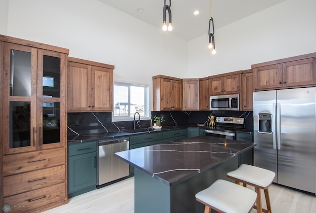 6652 32nd St S, Fargo, ND 58104 - kitchen with stainless steel appliances, a high ceiling, a sink, tasteful backsplash, and a breakfast bar area