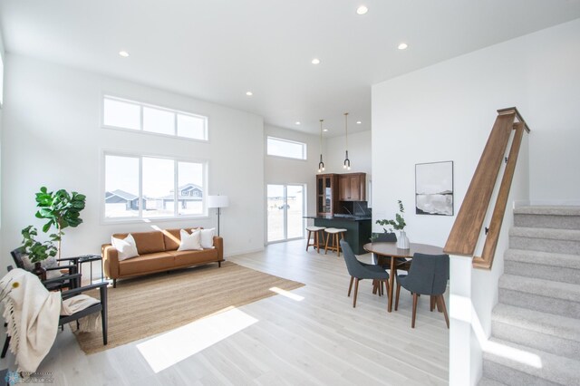 6652 32nd St S, Fargo, ND 58104 - living area with stairway, light wood-style floors, recessed lighting, baseboards, and a towering ceiling