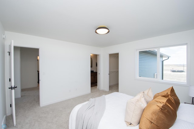 6652 32nd St S, Fargo, ND 58104 - bedroom featuring light carpet, a walk in closet, and a closet