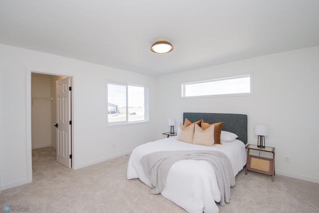 6652 32nd St S, Fargo, ND 58104 - bedroom featuring light carpet, a walk in closet, and baseboards