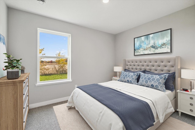 bedroom featuring light colored carpet and multiple windows