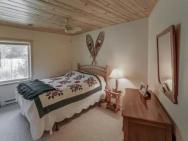 bedroom with carpet and wood ceiling