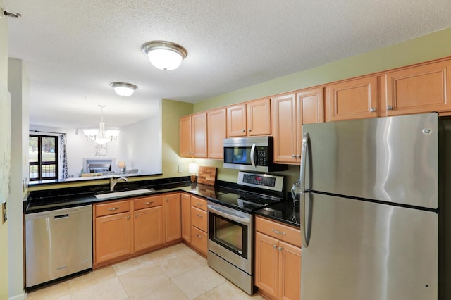 kitchen featuring stainless steel appliances, a chandelier, a textured ceiling, and sink