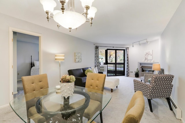 dining space featuring light carpet, baseboards, a baseboard radiator, a notable chandelier, and track lighting