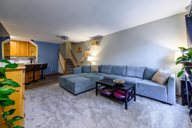 carpeted living room featuring a textured ceiling