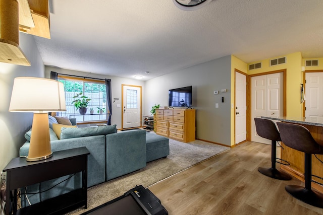 living room featuring a textured ceiling and light hardwood / wood-style floors