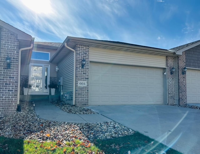 664 Shardlow Pl NE, Byron, MN 55920 - view of property exterior featuring brick siding, an attached garage, and driveway
