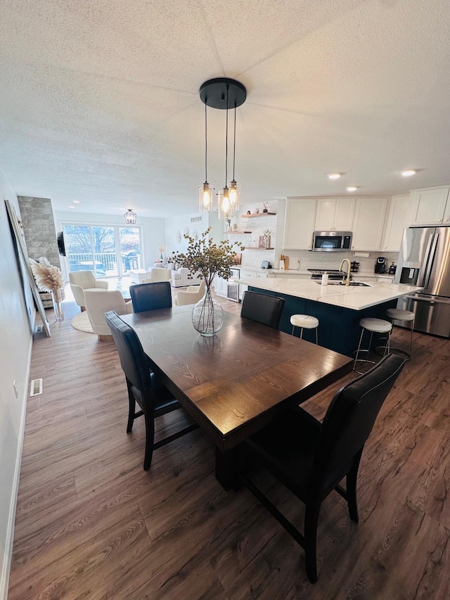 dining area with dark hardwood / wood-style flooring, a textured ceiling, and sink