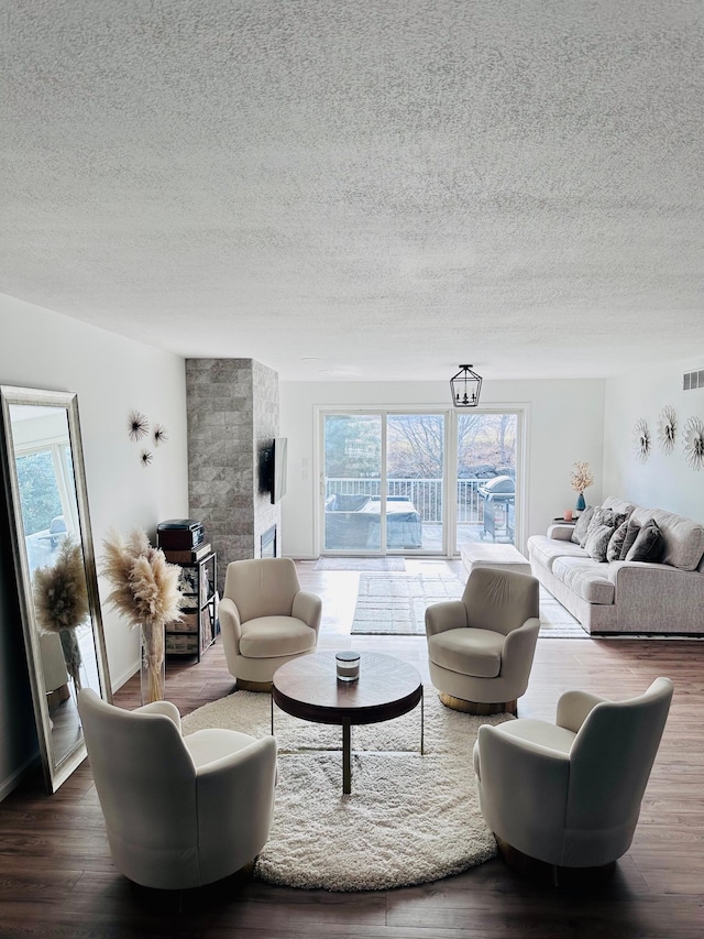 living room with wood-type flooring and a textured ceiling