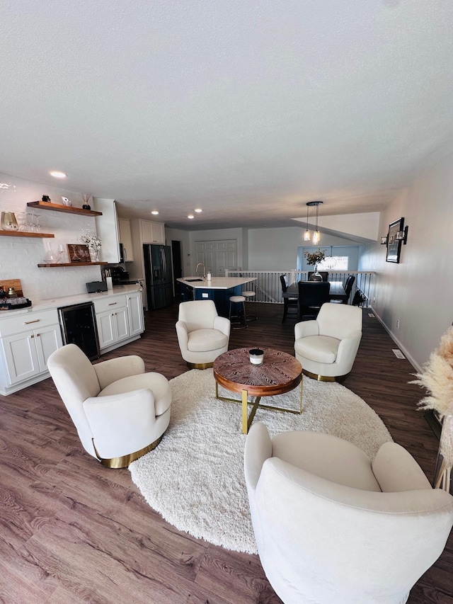 living room with a textured ceiling and dark wood-type flooring