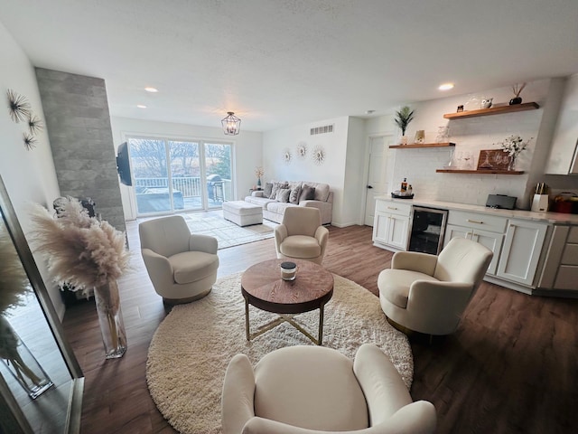 living room featuring bar area, hardwood / wood-style flooring, and beverage cooler