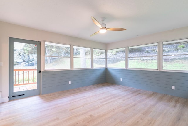 unfurnished sunroom featuring ceiling fan