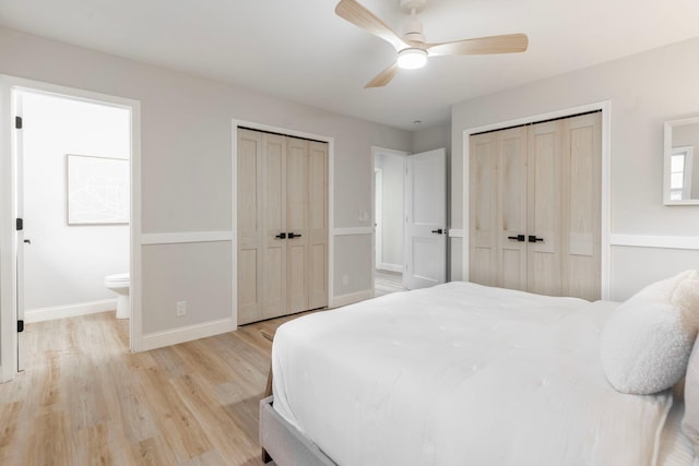 bedroom featuring connected bathroom, two closets, ceiling fan, and light hardwood / wood-style flooring