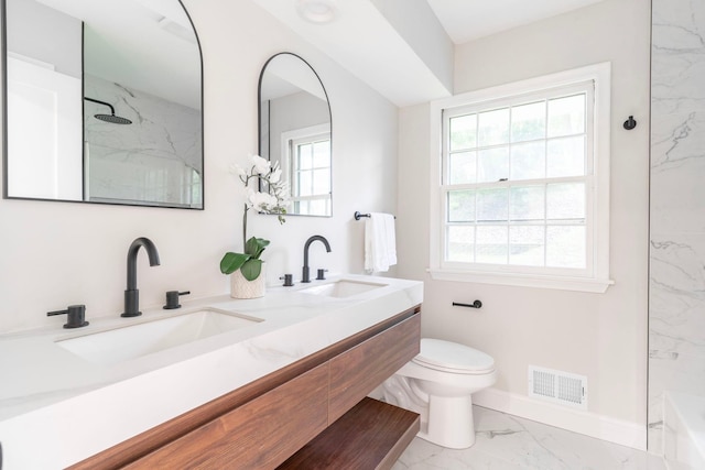 bathroom with vanity, toilet, and tiled shower