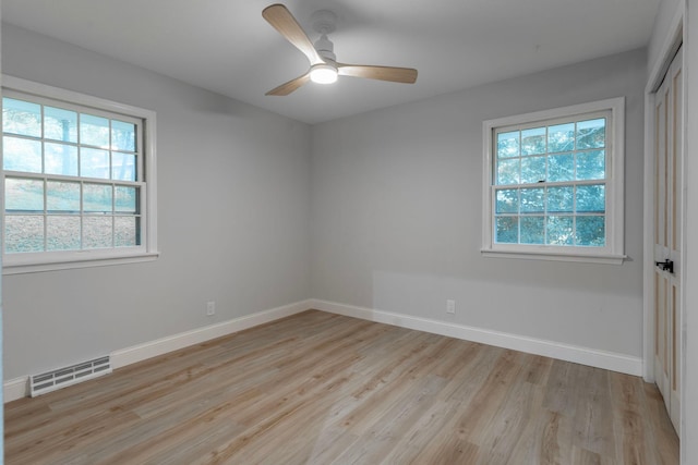 spare room with light wood-type flooring, a healthy amount of sunlight, and ceiling fan