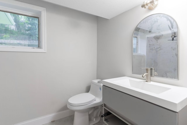 bathroom with vanity, toilet, and a textured ceiling