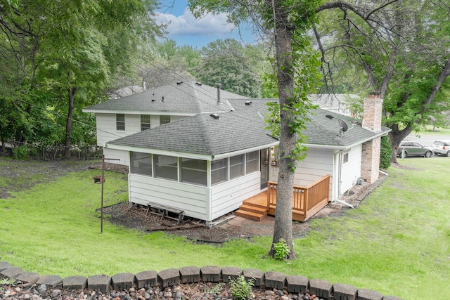 back of house with a deck, a lawn, and a sunroom