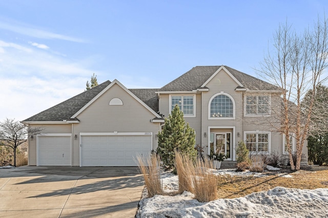 colonial-style house with a garage, concrete driveway, and roof with shingles