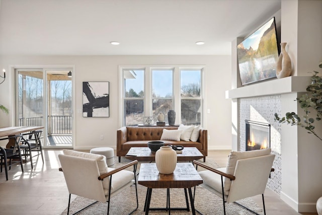 living room featuring light hardwood / wood-style floors and a tiled fireplace