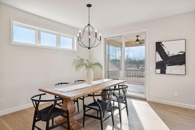 dining room with ceiling fan with notable chandelier, a healthy amount of sunlight, and light hardwood / wood-style flooring