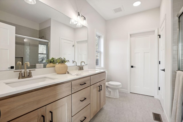 bathroom featuring vanity, toilet, and an enclosed shower